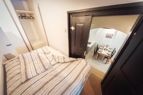 a small bedroom with a bed and a mirror at Loft w kamienicy in Duszniki Zdrój