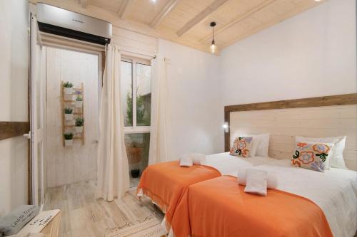 2 letti con lenzuola arancioni in una stanza con finestra di Casa na Travessa 2 a Faro