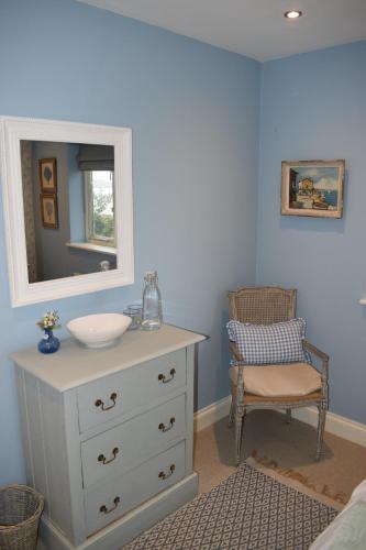a bathroom with a sink and a mirror and a chair at River View in Aldeburgh
