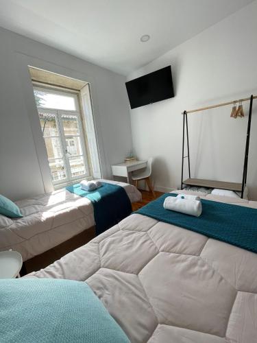 a bedroom with two beds and a window at Centro da Vila in Ponte de Lima