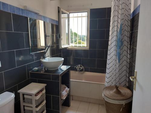 uma casa de banho com azulejos azuis, um lavatório e uma banheira. em Studio Golf Riviera - Axelle Loc'Appart em Mandelieu-la-Napoule