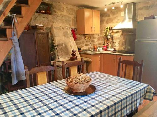 une cuisine avec une table avec un chiffon de table bleu et blanc dans l'établissement Casa rural Buxo Ribeira Sacra, à Carballedo