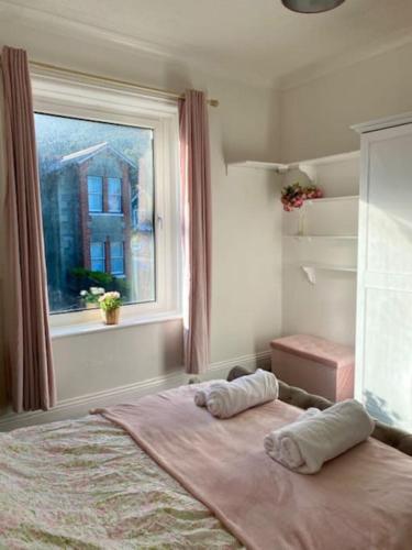 a bedroom with a bed with two pillows and a window at Peaceful Coastal Apartment in Ventnor