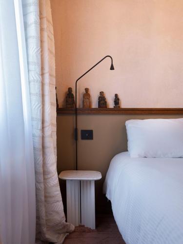 a bedroom with a bed and a table and a lamp at Paradis Agricole in Pietrasanta