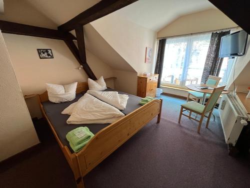 a bedroom with a bed and a table and a chair at Thüringer Hof in Ziegenrück