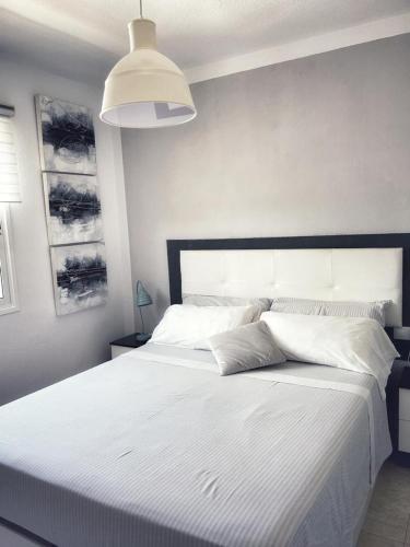 コラレホにあるLOS DELFINESのベッドルーム(大きな白いベッド、大きなヘッドボード付)