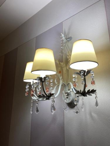 a chandelier with three lights on a wall at Casa dei Cherubini in Lucca
