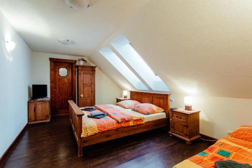 a attic bedroom with a bed and a skylight at Pivovar BUC Kvačany in Kvačany