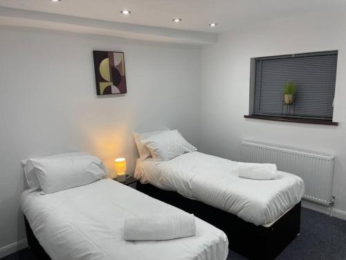 two beds in a room with white walls at ED Colchester House in Colchester