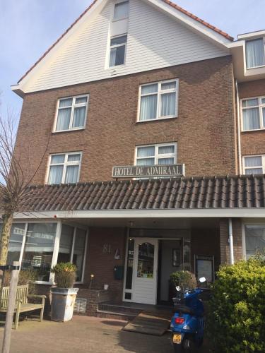 a moped parked in front of a brick building at Hotel de Admiraal in Noordwijk aan Zee