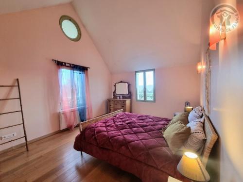 um quarto com uma cama com um cobertor roxo em La Maison de Nicole em Mousseaux-sur-Seine