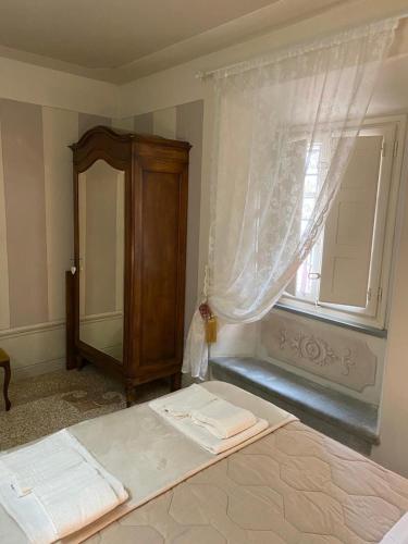 a bedroom with a bed with a window and a dresser at Casa dei Cherubini in Lucca