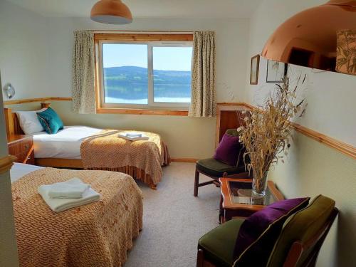 a hotel room with two beds and a window at Spacious Sea View Home 5 miles from Inverness in North Kessock