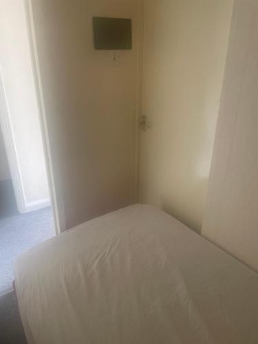 Schlafzimmer mit einem weißen Bett und einem TV an der Wand in der Unterkunft Montrose Street in Marton