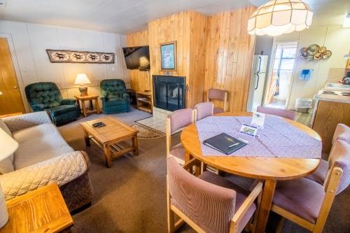 a living room and a dining room with a table at Castle Mountain Lodge in Estes Park