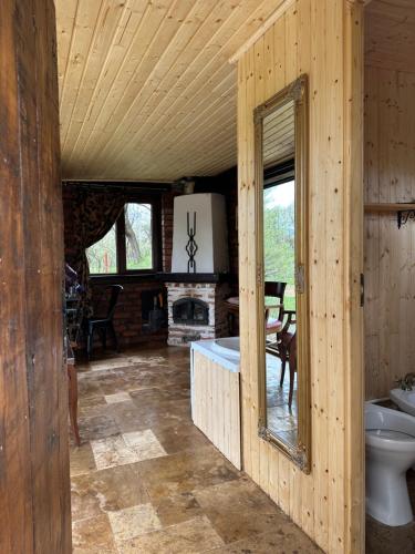 eine Blockhütte mit einer Badewanne und einem Kamin in der Unterkunft Crângul Verde in Minciuneşti