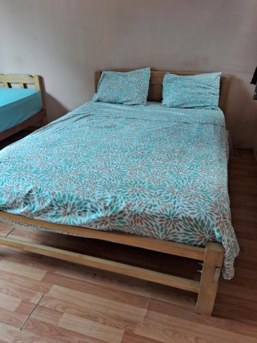 a bed with a blue comforter and pillows on it at Casa sanacion Elixir in Pucallpa