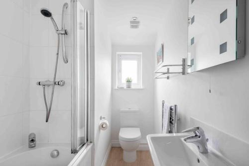 La salle de bains blanche est pourvue de toilettes et d'un lavabo. dans l'établissement Little Haven St Ives, à St Ives
