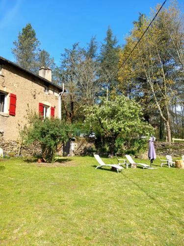 a group of chairs in a yard next to a house at Cèdres Bleus de Joany chez Nathalie in Viviez