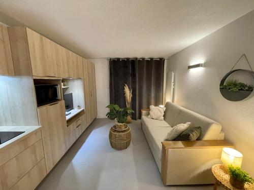 a small living room with a couch and a kitchen at Le Studio de la Digue in Wissant