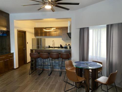 a kitchen with a bar and some chairs and tables at Picturesque Ocean View Condo in San Felipe de Puerto Plata