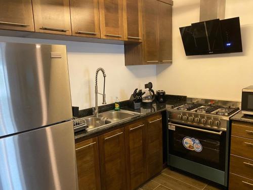 a kitchen with a stainless steel refrigerator and a sink at Picturesque Ocean View Condo in San Felipe de Puerto Plata