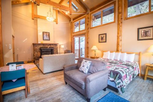 a bedroom with a bed and a chair and a fireplace at Castle Mountain Lodge in Estes Park