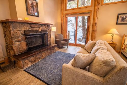 a living room with a couch and a fireplace at Castle Mountain Lodge in Estes Park