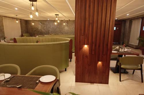 a restaurant with tables and chairs and a dining room at Hotel Preethi Classic Towers in Ooty