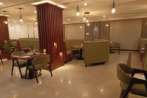 a dining room with tables and chairs and lights at Hotel Preethi Classic Towers in Ooty
