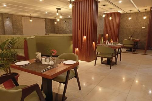 a dining room with two tables and chairs and candles at Hotel Preethi Classic Towers in Ooty