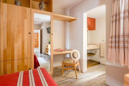 Habitación pequeña con cama y escritorio. en Suites Parador Santo Domingo de G., en Oaxaca City