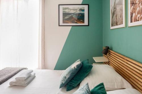 - une chambre avec un lit aux murs verts dans l'établissement Cocon douillet, à Brest