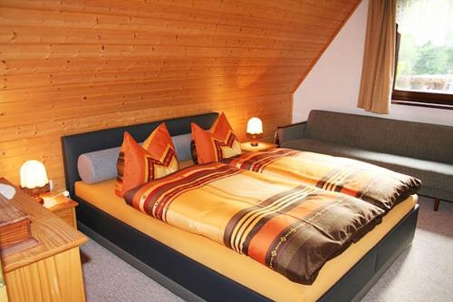 a bedroom with a large bed with orange pillows at Ferienzimmer Hämer in Prerow