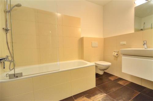een badkamer met een bad, een toilet en een wastafel bij Apartment Konstanzia - by Alpen Apartments in Zell am See