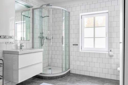 a bathroom with a glass shower and a sink at Villa Alpenbach - by Alpen Apartments in Zell am See