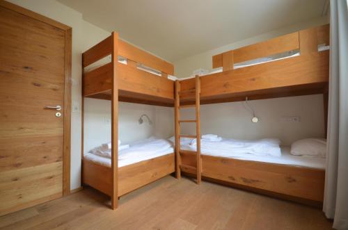 Zimmer mit 2 Etagenbetten und einer Tür in der Unterkunft Apartment Diana - by Alpen Apartments in Zell am See