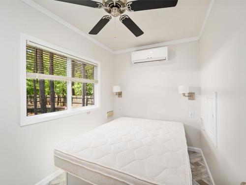 Habitación blanca con cama y ventilador de techo. en Sun Outdoors Ocean City Gateway, en Whaleyville