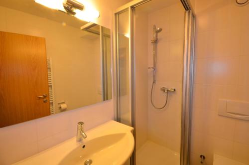 y baño con ducha, lavabo y espejo. en Select Top 10 - by Alpen Apartments, en Piesendorf