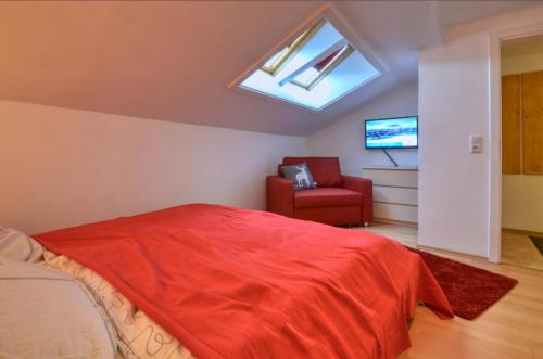 ein Schlafzimmer mit einem Bett, einem Stuhl und einem Dachfenster in der Unterkunft Apartment Lisa - by Alpen Apartments in Zell am See
