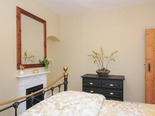 a bedroom with a bed and a mirror and a dresser at Skylarks in Looe