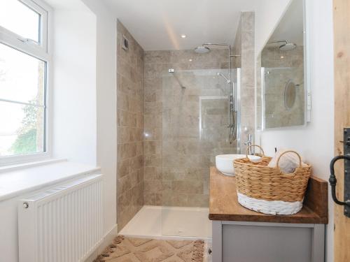 a bathroom with a shower and a sink and a tub at Skylarks in Looe