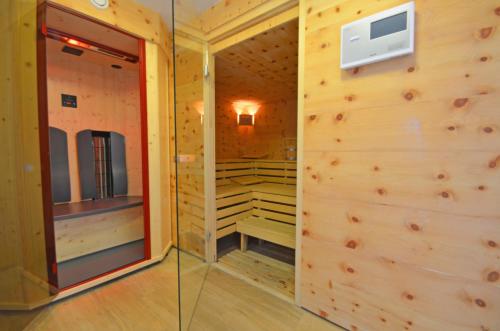 カプルーンにあるResidence Alpin - by Alpen Apartmentsの木製の壁とガラスドアのサウナ