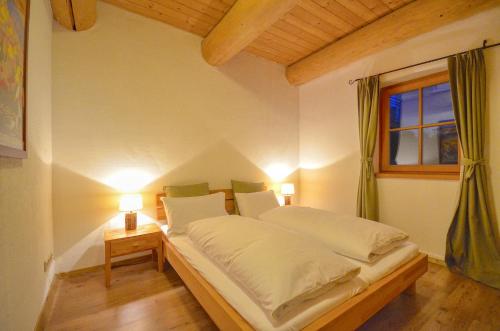 a bed in a room with two lamps and a window at Chalet Stabler - by Alpen Apartments in Zell am See