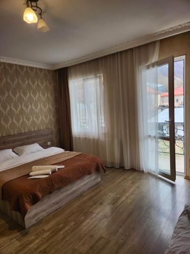 una camera da letto con un letto e una grande finestra di MOON NIGHT a Kazbegi