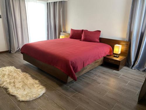 a bedroom with a bed with a red bedspread and a rug at Picturesque Ocean View Condo in San Felipe de Puerto Plata