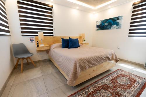 a bedroom with a bed and a desk and a chair at Baja Suites - Departamentos Vacacionales in Ensenada