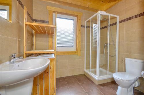 a bathroom with a sink and a shower and a toilet at Chalet Seven - by Alpen Apartments in Zell am See