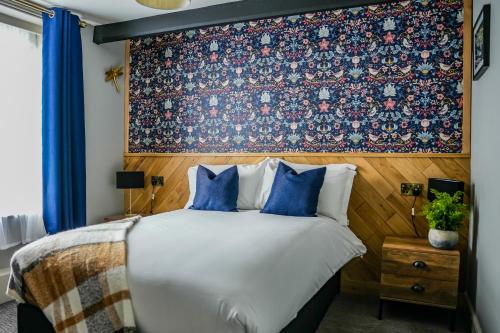 1 dormitorio con 1 cama grande y papel pintado con motivos florales en The Old Mill, en Salisbury