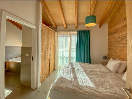 a bedroom with a bed and a large window at Gletscherblick 2 - by Alpen Apartments in Zell am See